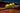 Tennis racket with five yellow tennis balls balanced on strings on clay court background