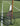 Two tennis racquets with white grips resting against a net post on a grass tennis court.