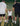 Three men on tennis court performing strength training exercise with one man sitting and two men helping him stand up