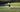 woman playing tennis on outdoor court with tennis racket in action swing