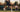 Tennis player hitting powerful shot on court with coach watching holding tennis racket