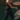 Blurred motion of a woman executing a forehand technique with a tennis racket and ball outdoors.