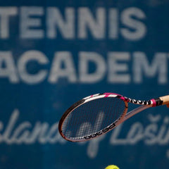 Tennis player holding racquet at tennis academy court, learning to play tennis beginner guide