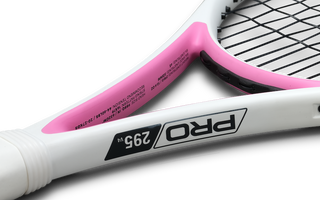 Close-up of a white and pink junior tennis racket frame displaying the model name "PRO 295 v4" and specifications on the inner throat.