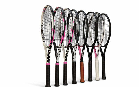 Set of carbon fibre tennis rackets with varied designs and grip colors, arranged in a row against white background