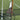 Two tennis racquets with white grips leaning against a net post on a grass tennis court symbolizing tennis racquet stringing tension.