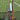 Two tennis rackets with white grips leaning against a net on a grass tennis court, illustrating the overgrip vs replacement grip comparison.