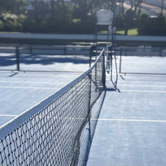 empty tennis court with net and clear court lines on sunny day