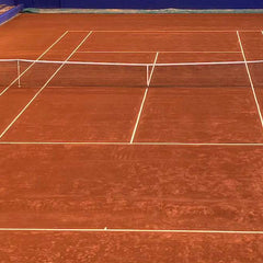 Official clay tennis court showing marked lines and net illustrating standard tennis court size dimensions for singles and doubles matches