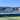 UK club tennis courts with surrounding buildings and clear blue sky in the background