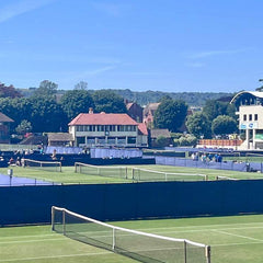 UK club tennis courts with surrounding buildings and clear blue sky in the background