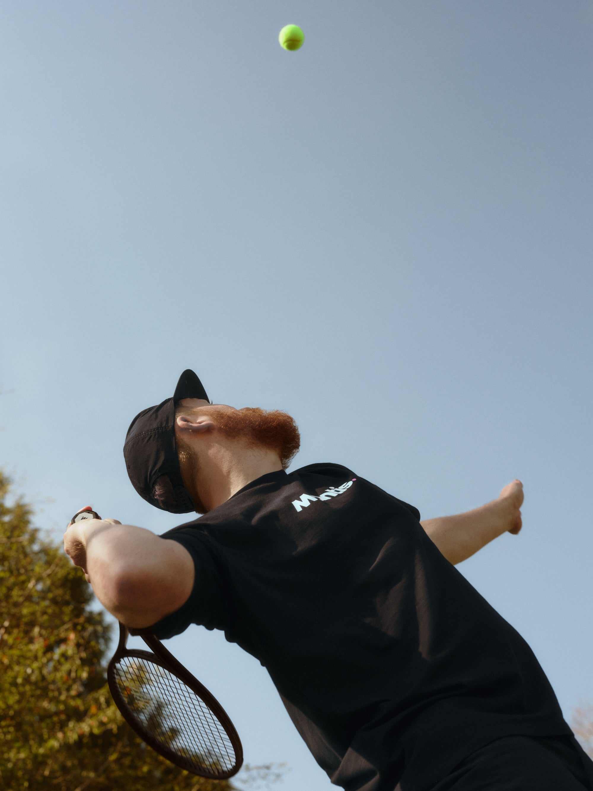 tennis player serving with focused tennis ball and racket emphasizing tennis strings tension concept