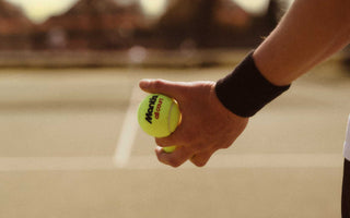 tennis player holding tennis ball on court ready for volley drills practice