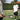 Two men playing tennis on a green court with one preparing to hit a ball using a pink and black tennis racket, showcasing best tennis rackets for spin.
