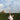 Tennis player executing a top spin tennis serve with racquet and ball in motion on court