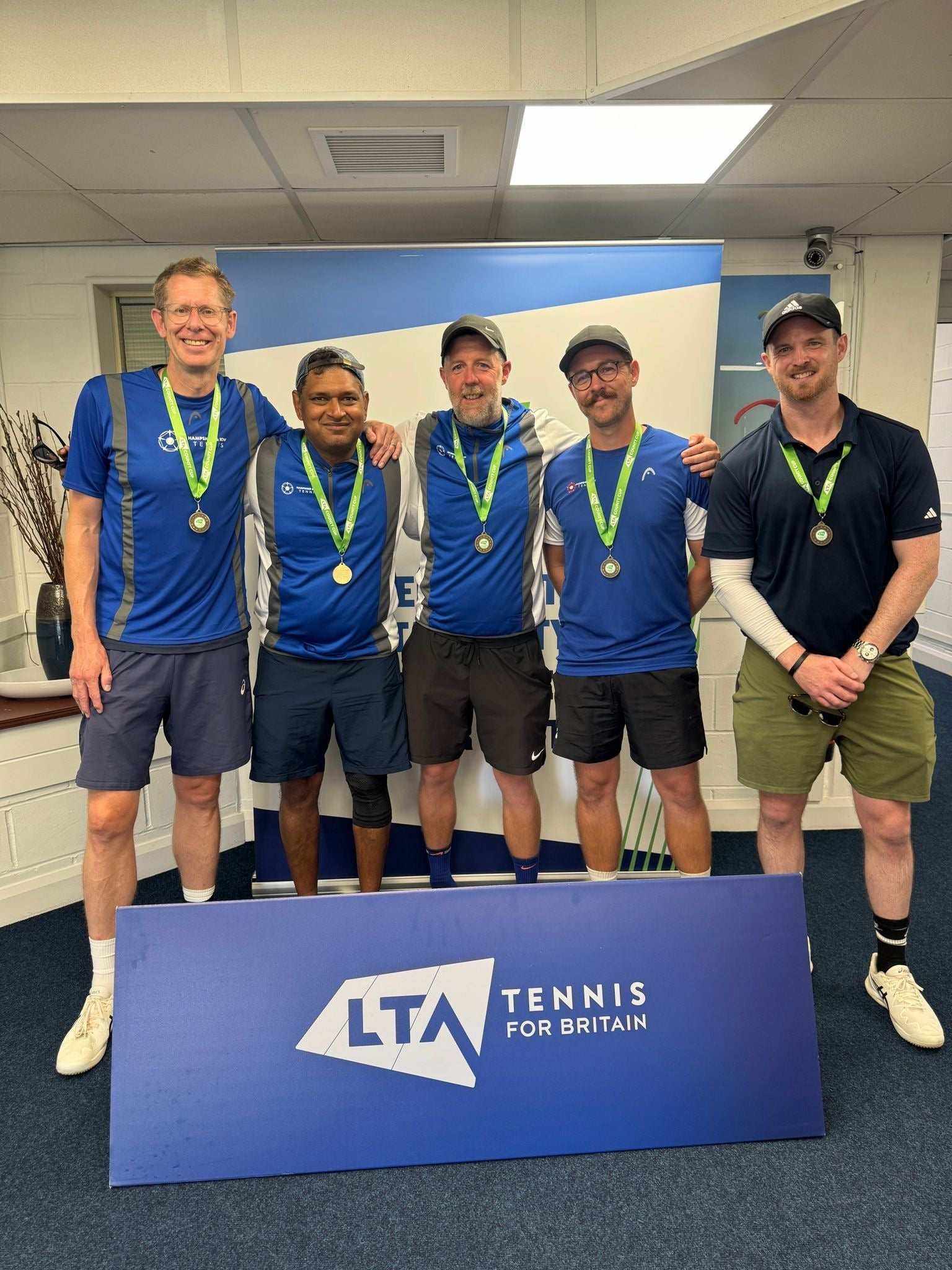 Amateur team tennis players celebrating with medals at LTA Tennis for Britain event