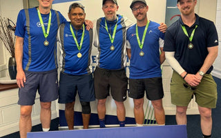 Amateur team tennis players celebrating with medals at a Tennis for Britain event